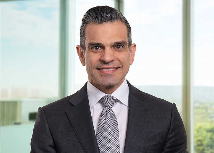 A photo of George Yatzis looking straight ahead with a view of Adelaide in the background