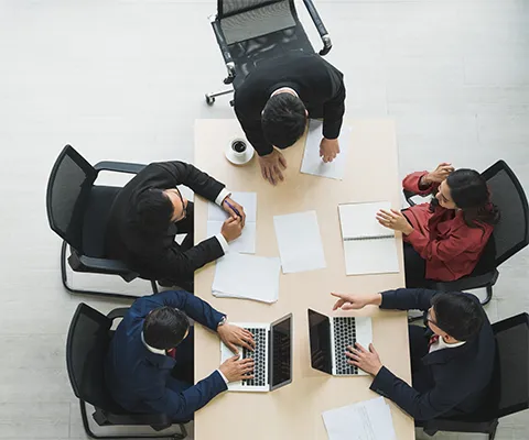 People sit around a desk and work