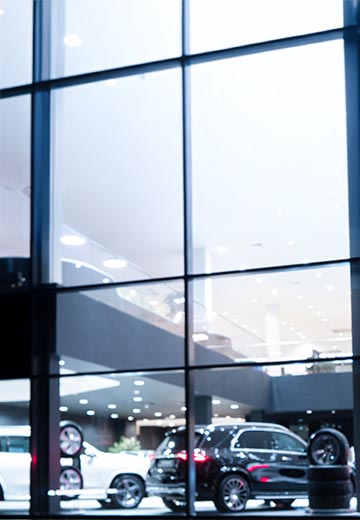 Blurred background with car dealership exterior.