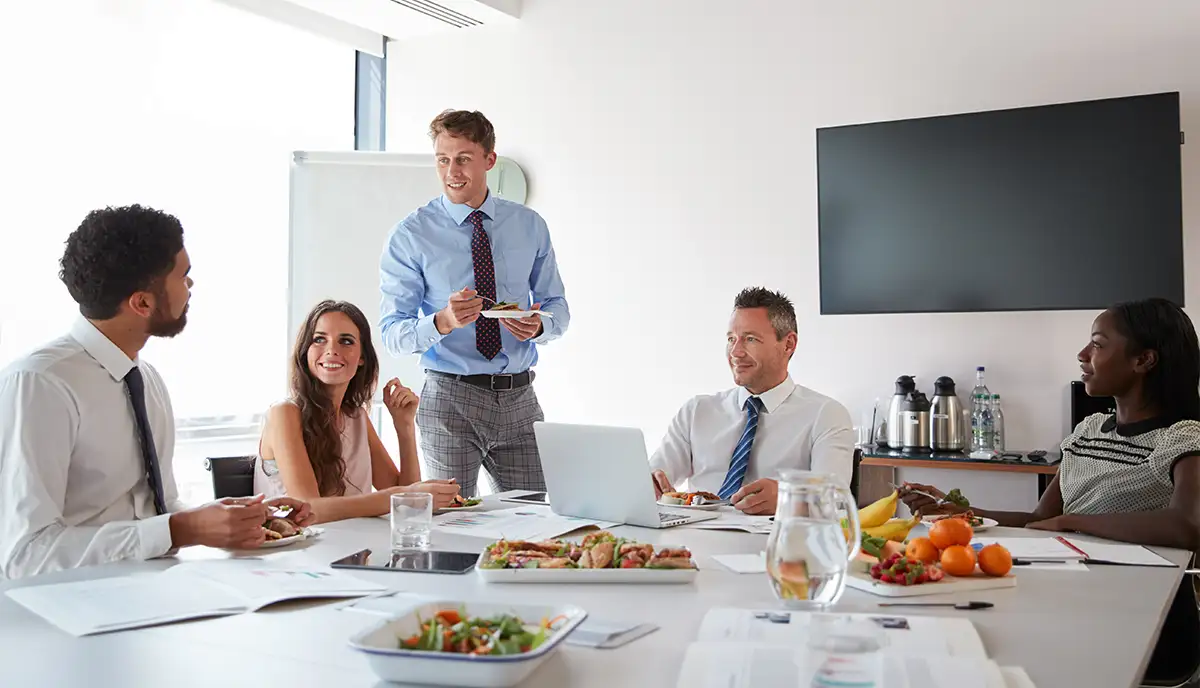 Colleagues eating lunch in a boardroom.