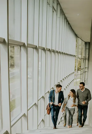 Three colleagues walking up the stairs in an office.